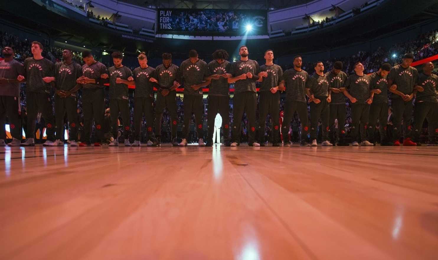 Toronto Raptors lock arms during anthems before preseason game against Golden State
